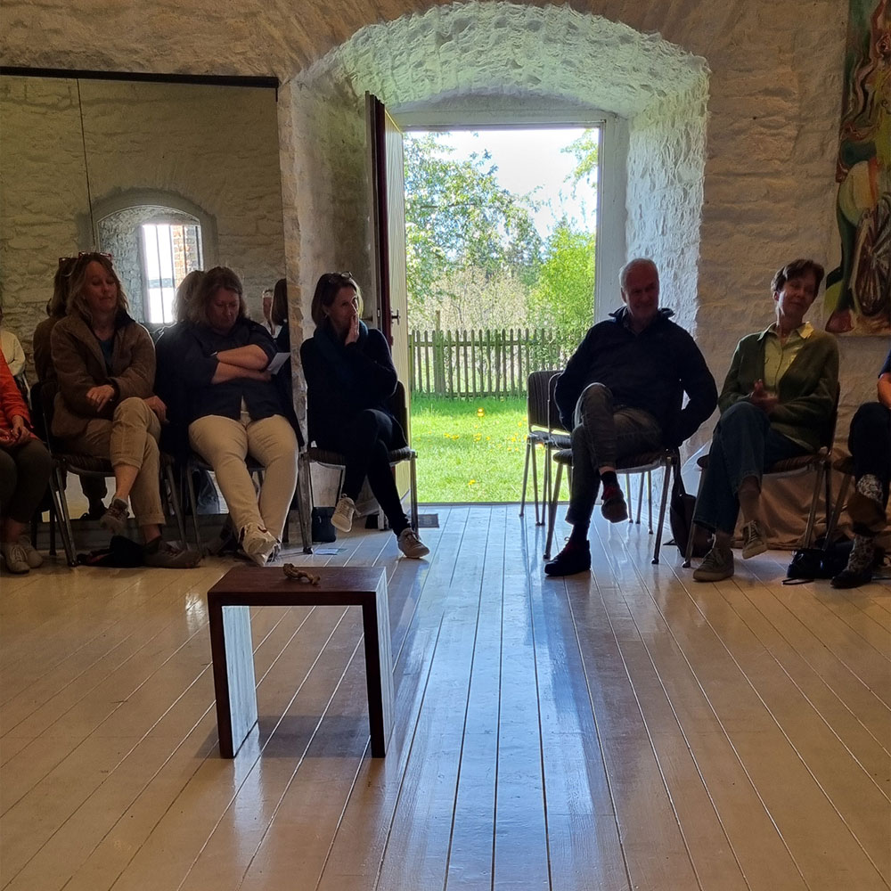 Stiftung Erdheilungsplaetze 1. Wachtberger Convivium In der Wachtberger Mühle herrschte besondere Stimmung. Die Teilnehmenden sitzen in einem Stuhlkreis in dem runden Raum.