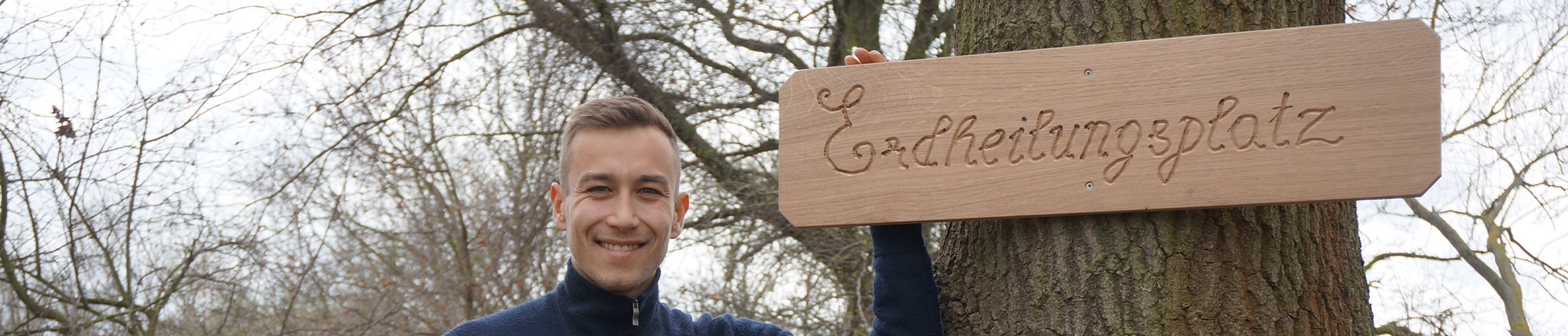 Jan neben dem neuen Schild auf dem Erdheilungsplatz 